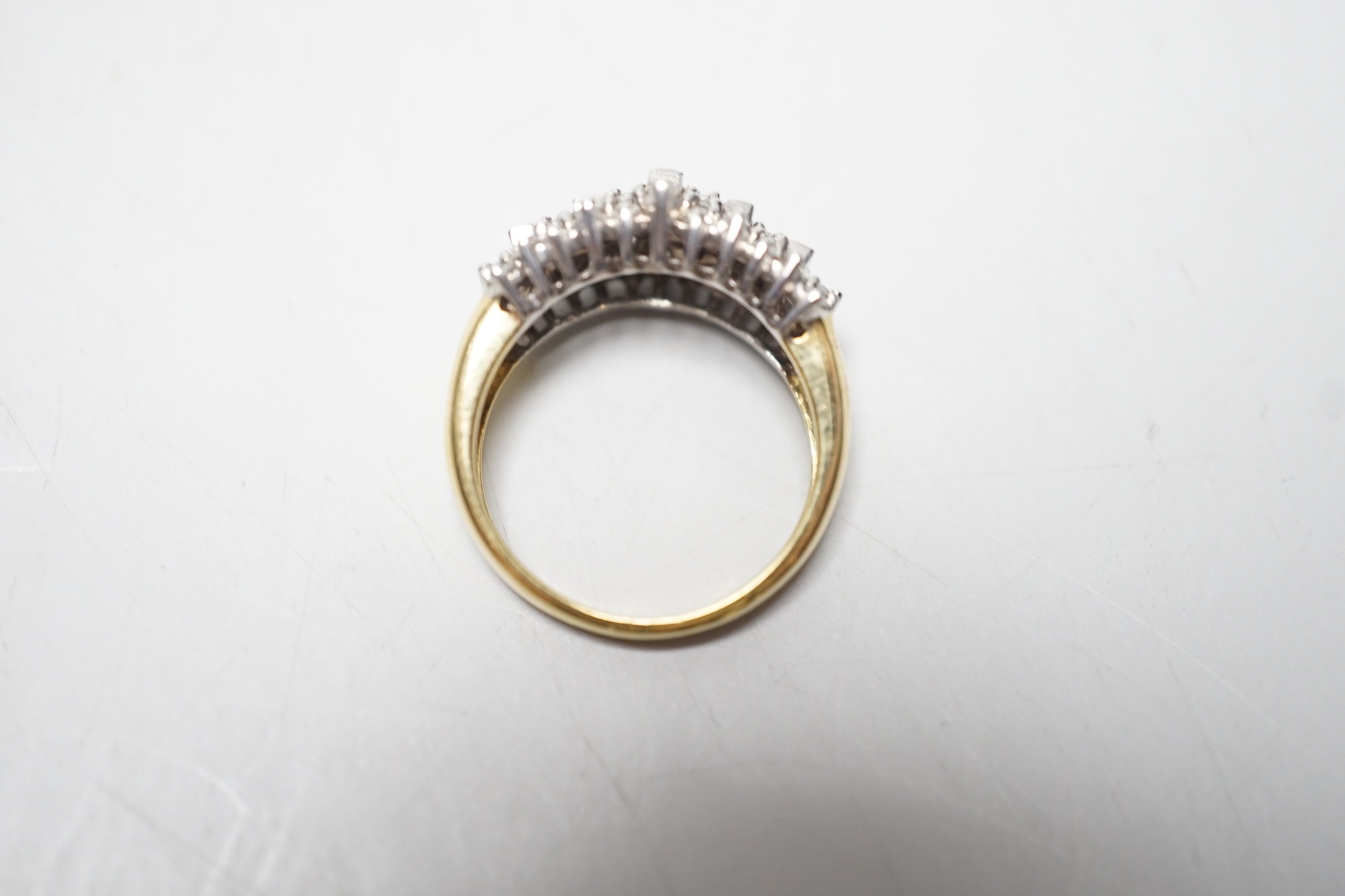 A modern yellow metal, round and baguette cut diamond set half hoop cluster ring, size L/M, gross weight 5.6 grams.